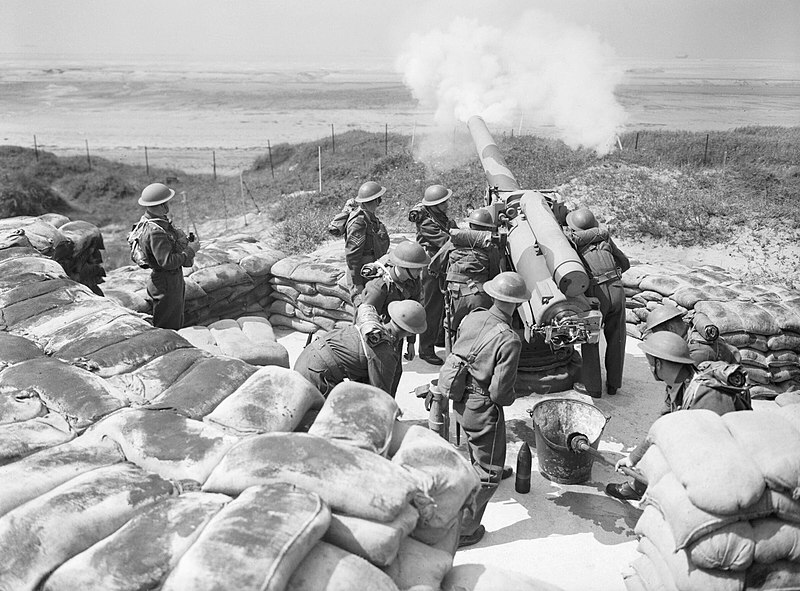 Artillery being fired at Fort Crosby, 1 August 1940, with soldiers standing by