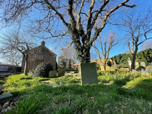 Photograph of the Ancient Chapel of Toxteth and its graveyard, under a blue sky